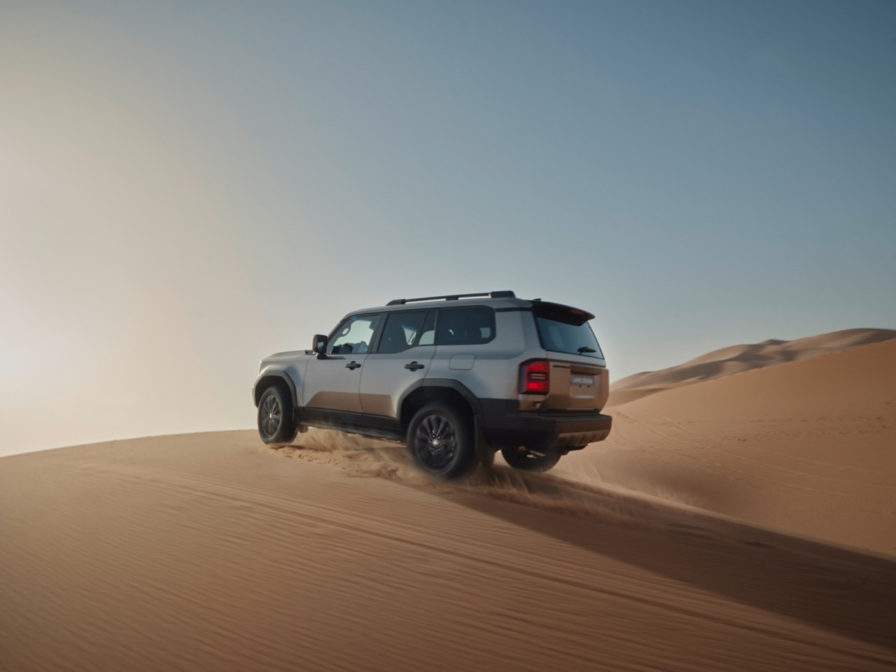 Een Land Cruiser rijdt door de woestijn